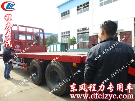 李先生正在量东风后双桥平板运输车板长