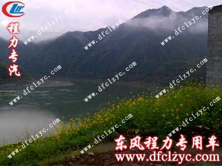湖北程力东风天锦多功能洒水车途经盛开的油菜花地