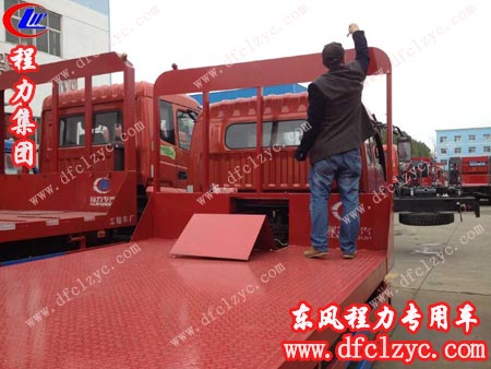 钟先生跳上车检查东风多利卡平板运输车