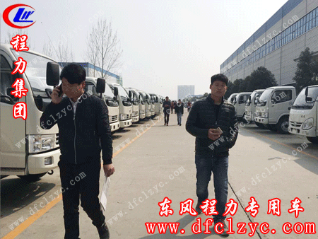 湖北程力销售一部张经理与客户走在东风底盘展示区的情景