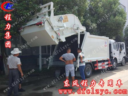 杨先生一行三人在湖北程力集团压缩垃圾车厂看车