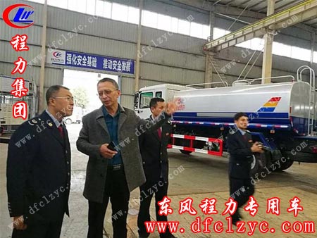 在程力标准化生产车间，何波局长（左）认真听取袁昌才总监介绍工作情况。