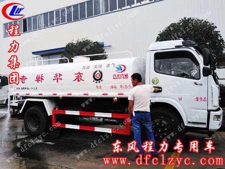 司机师傅正在给洒水车装水，进行质检工作
