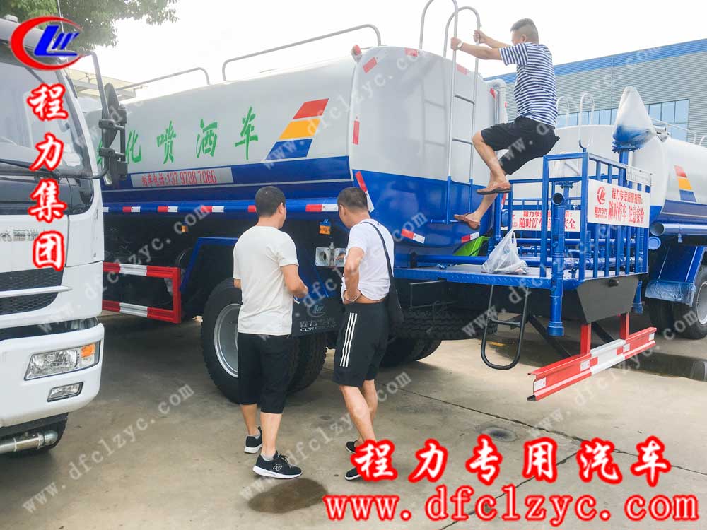 程力集团送车师傅在耐心给宋总及同伴介绍东风D9洒水车的操作方法