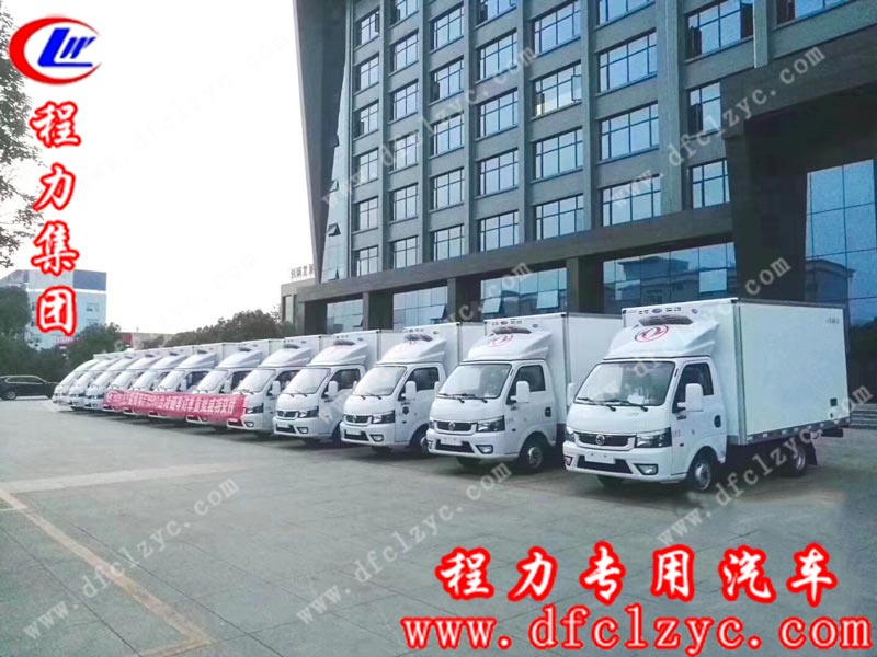 湖北程力集团生产首批待发的国六东风途逸冷藏车在程力集团大楼前留影